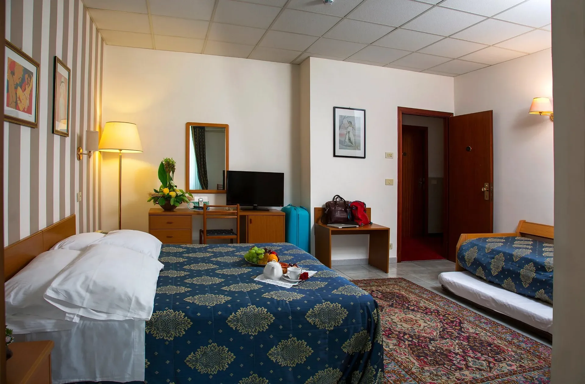 Camera tripla con letto matrimoniale, letto singolo, scrivania e TV