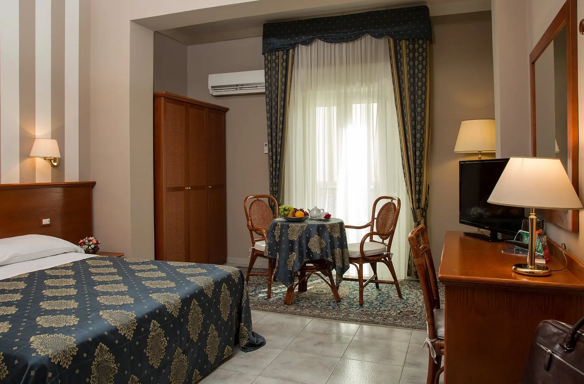 Camera con letto matrimoniale, tavolino, armadio e angolo relax