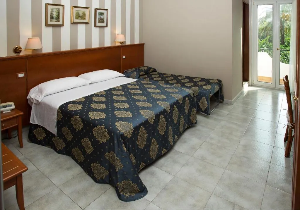 Camera con letto matrimoniale, copriletto blu e accesso al balcone