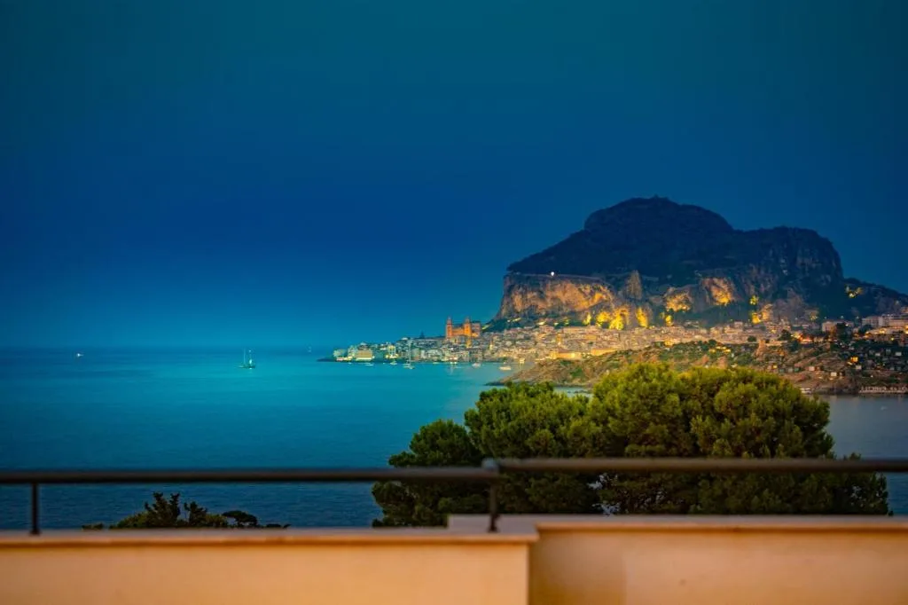 Vista serale di Cefalù illuminata e della Rocca dal terrazzo