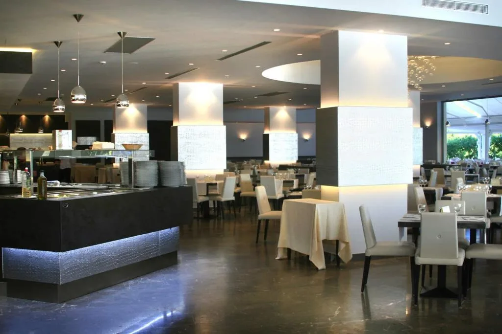 Interno del ristorante dell'hotel con buffet, colonne decorate e illuminazione soffusa