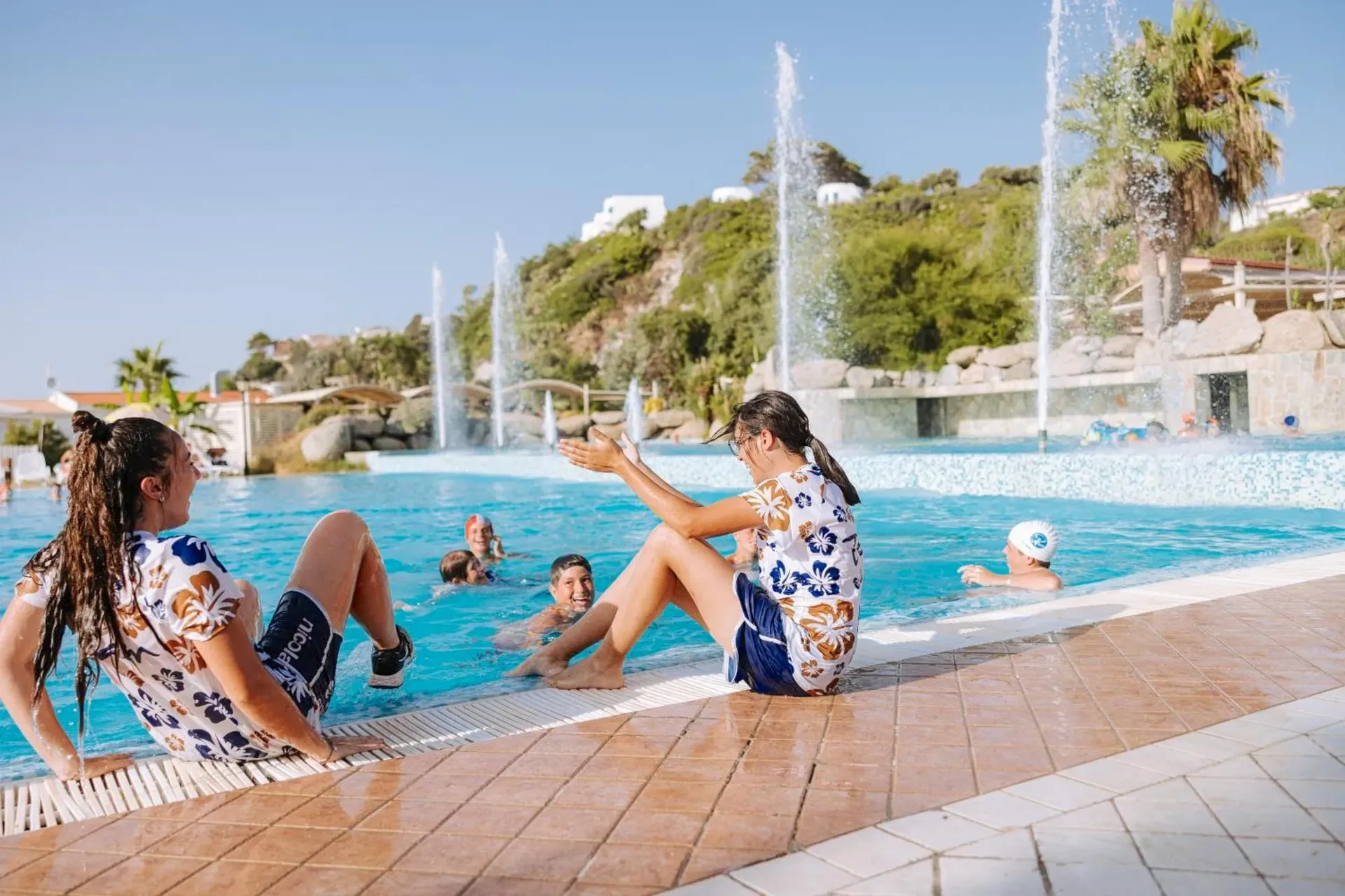 Bambini e animatori giocano a bordo della piscina con fontane d'acqua