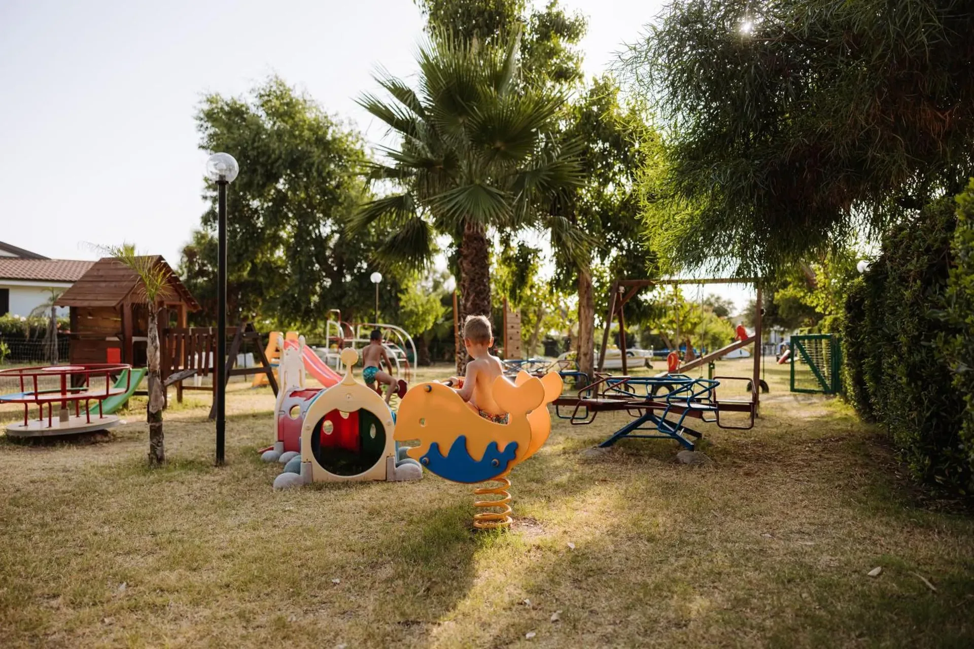 Area giochi per bambini nel giardino con scivoli, altalene e giostrine colorate