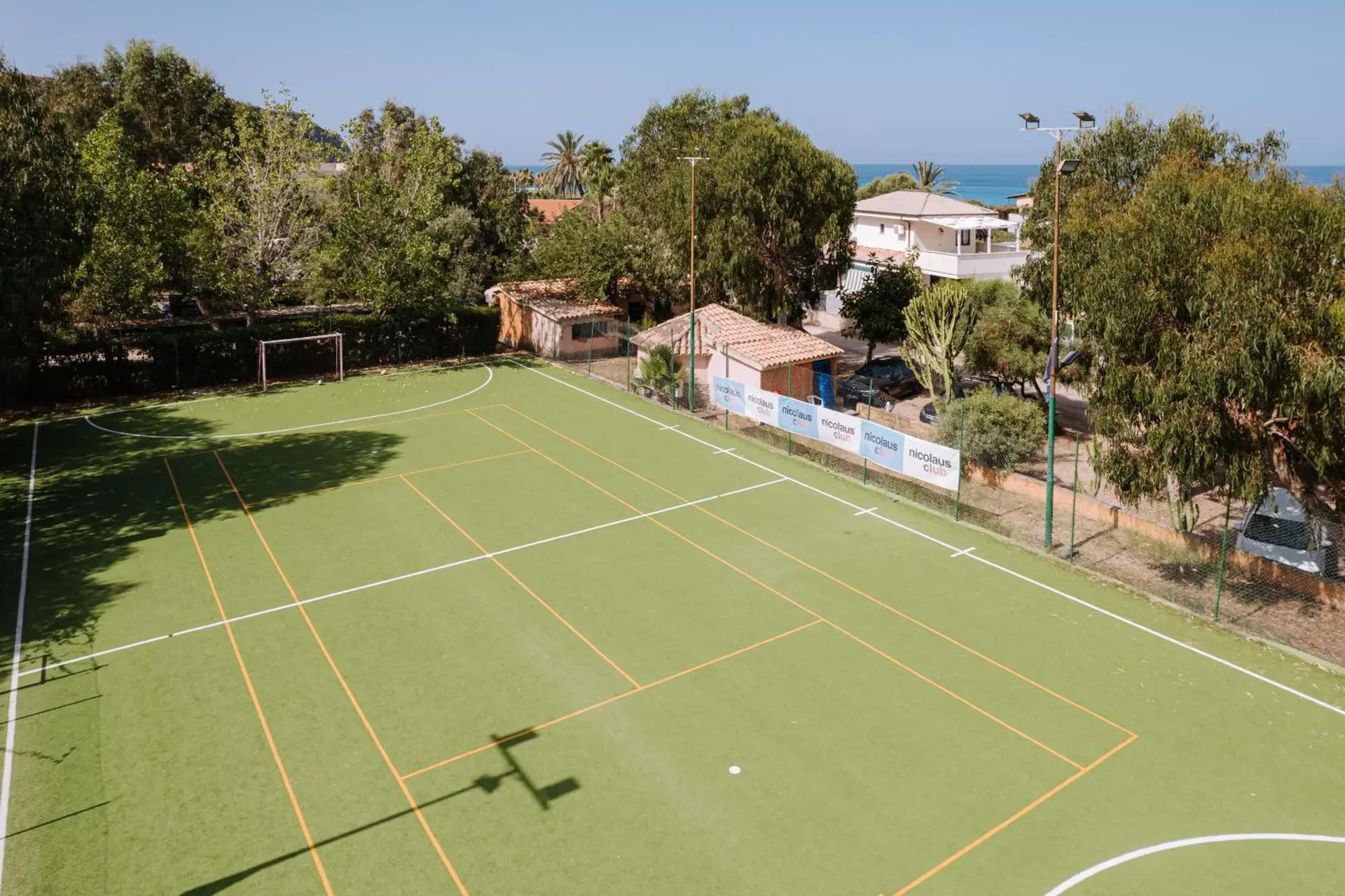 Campo sportivo polivalente in erba sintetica con vista mare sullo sfondo