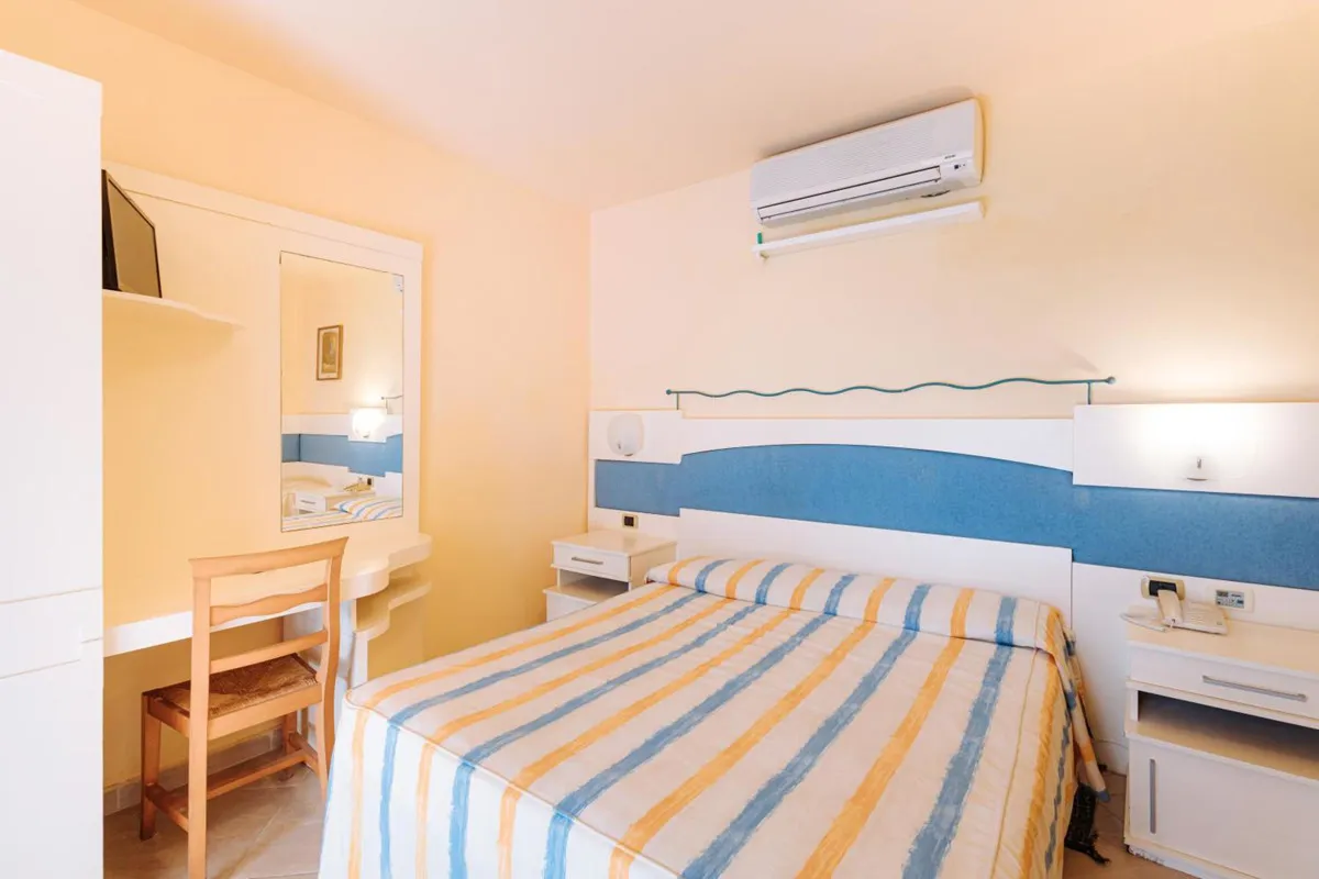 Camera da letto matrimoniale con aria condizionata, specchio e arredi essenziali
