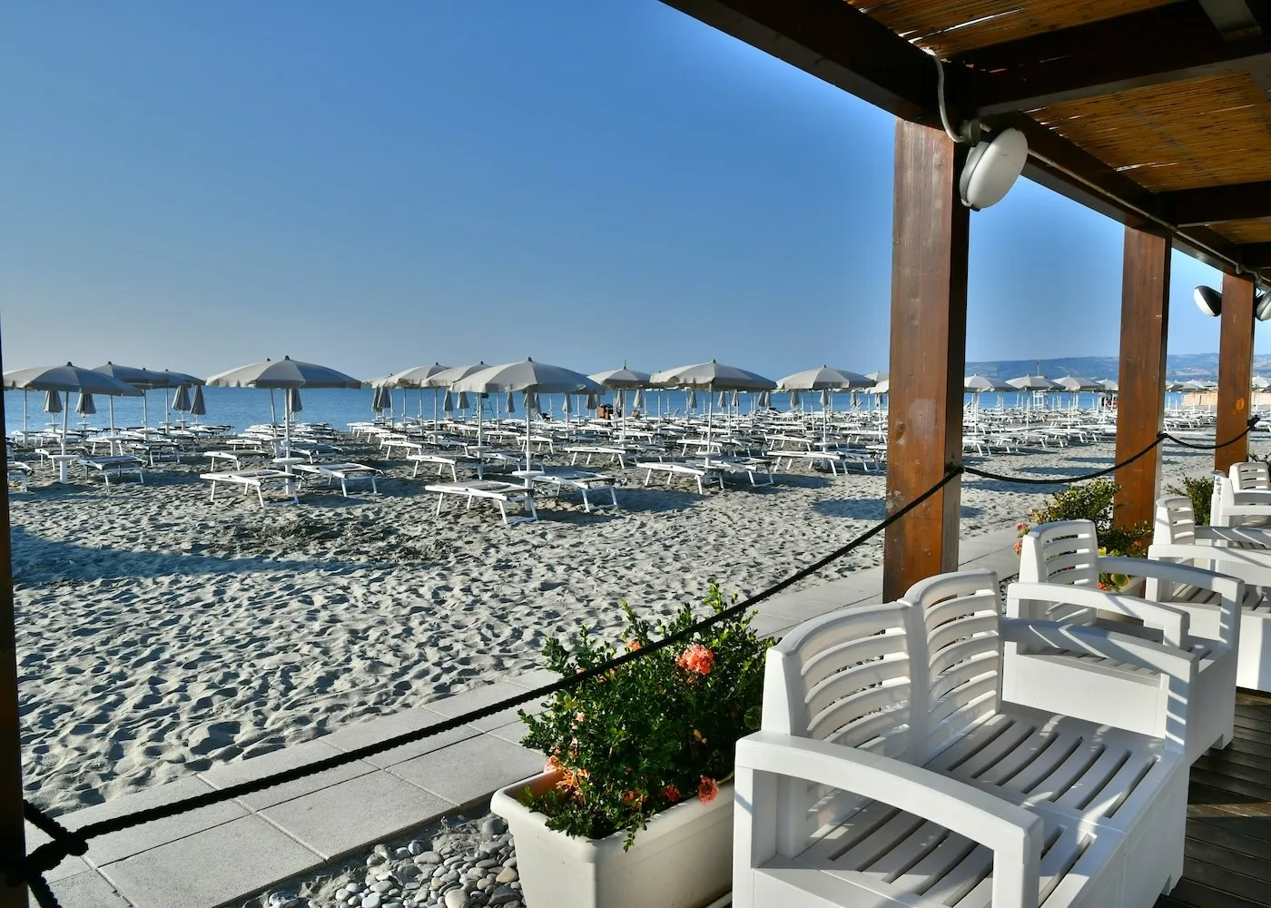 Terrazza in legno del beach bar affacciata sugli ombrelloni e il mare