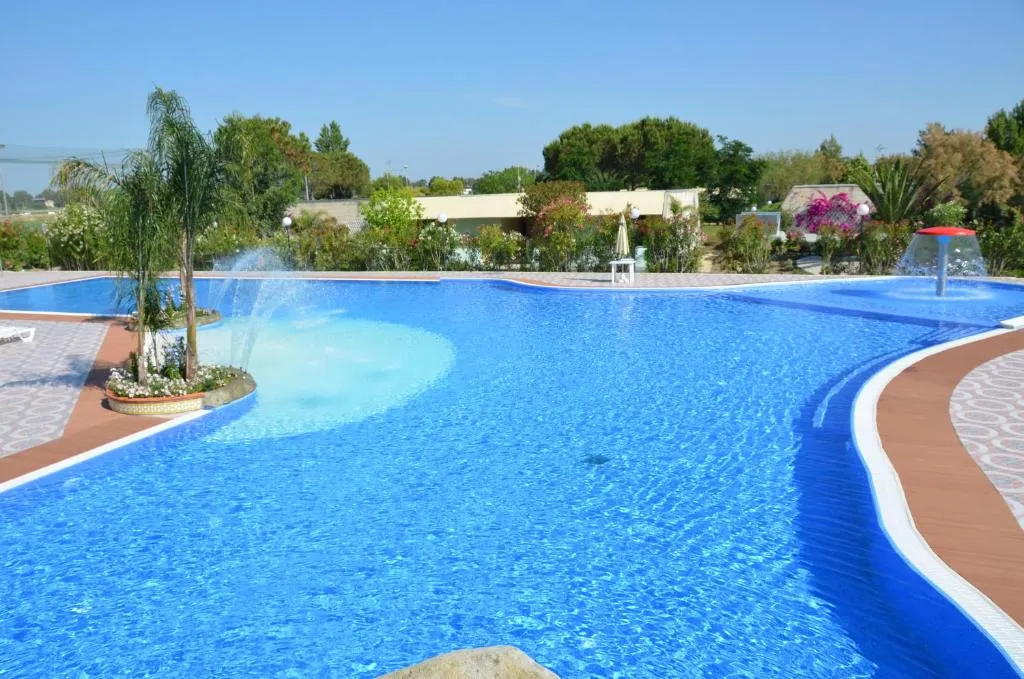 Piscina a forma libera con isola centrale fiorita e giochi d'acqua