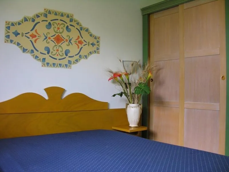 Dettaglio di camera da letto con letto matrimoniale, armadio e decorazione a parete
