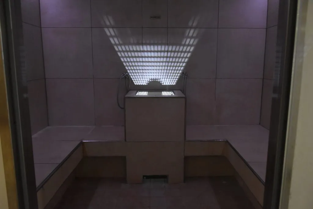 Bagno turco con rivestimento in piastrelle chiare e illuminazione soffusa