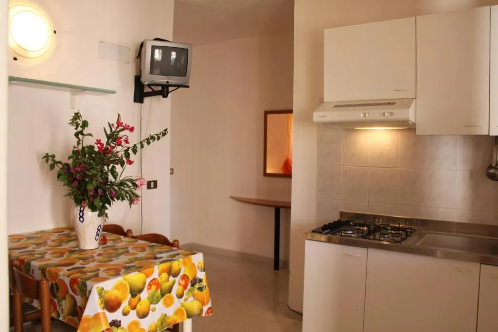 Cucina di appartamento con angolo cottura, tavolo e televisore