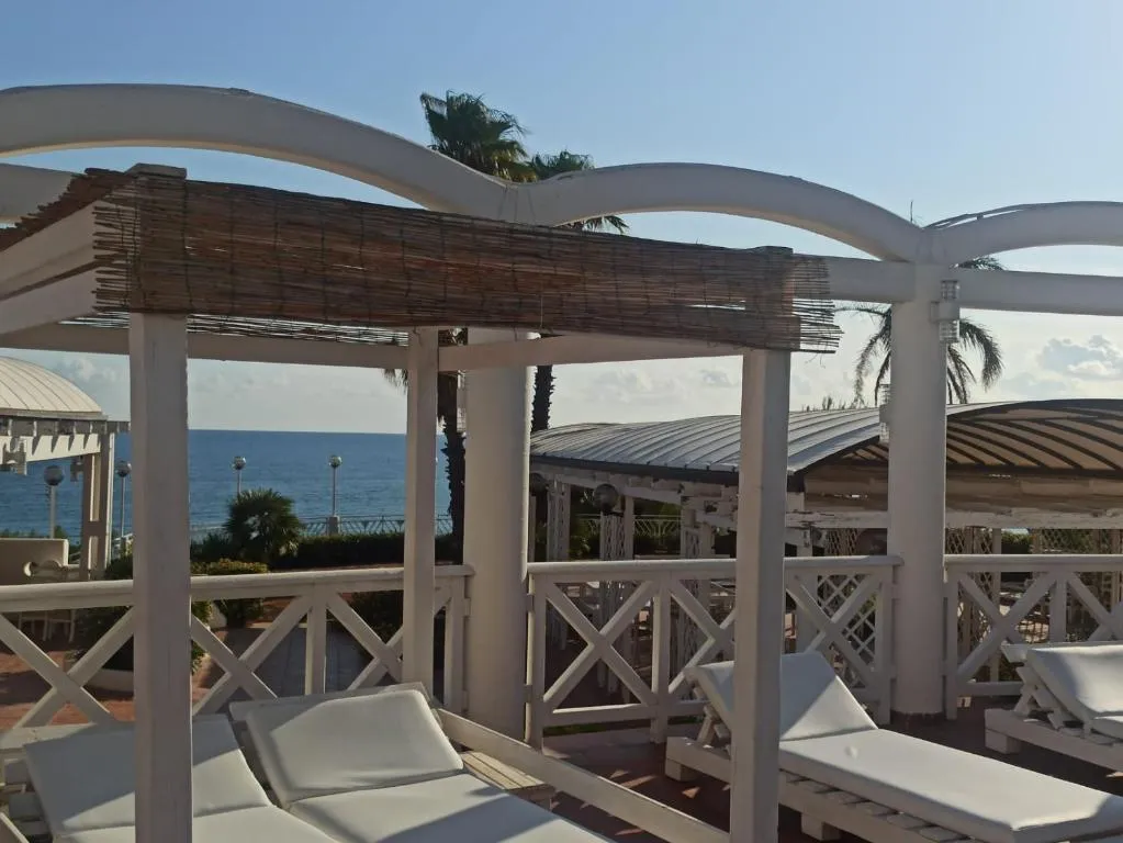 Gazebo bianco con lettini vista mare a bordo piscina
