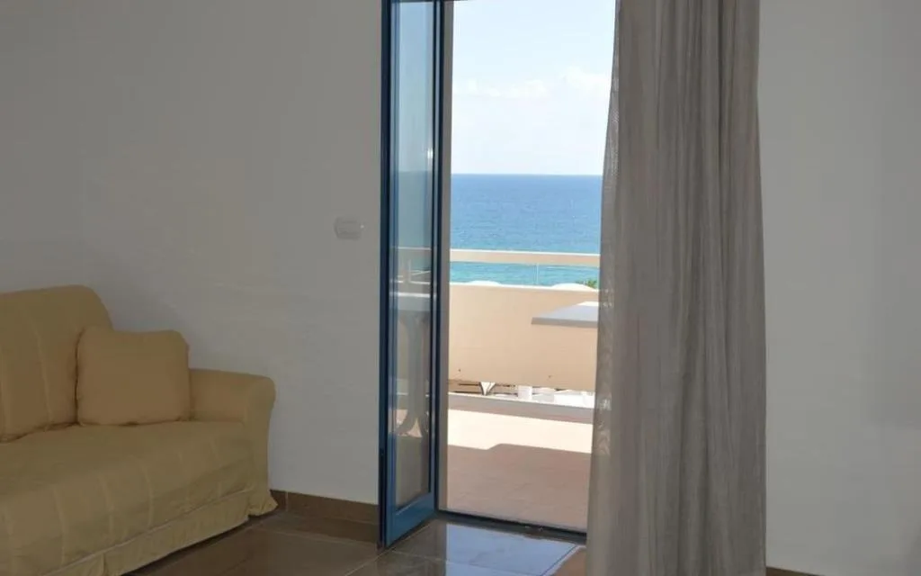 Interno con divano e porta-finestra affacciata sul mare