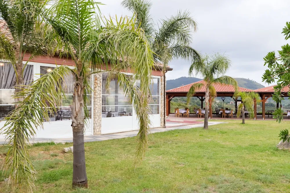 Giardino del resort con palme e struttura del ristorante esterno