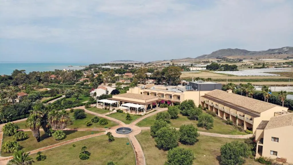 Veduta aerea del resort immerso nel verde con fontana centrale e mare all'orizzonte