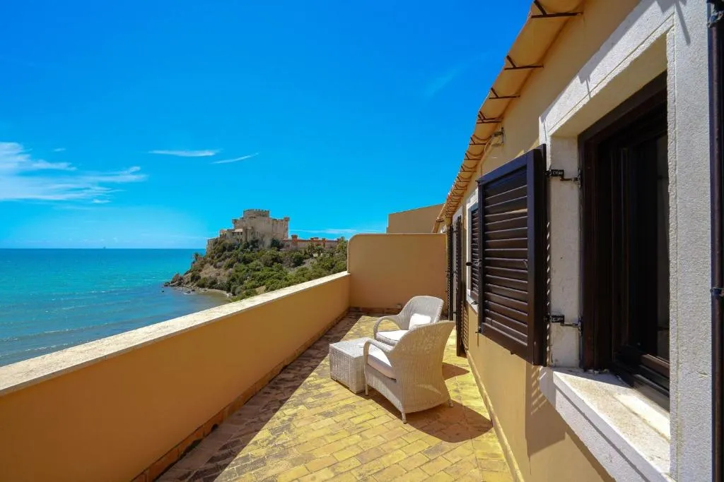 Terrazza privata con poltrone in vimini e vista sul mare e sul castello
