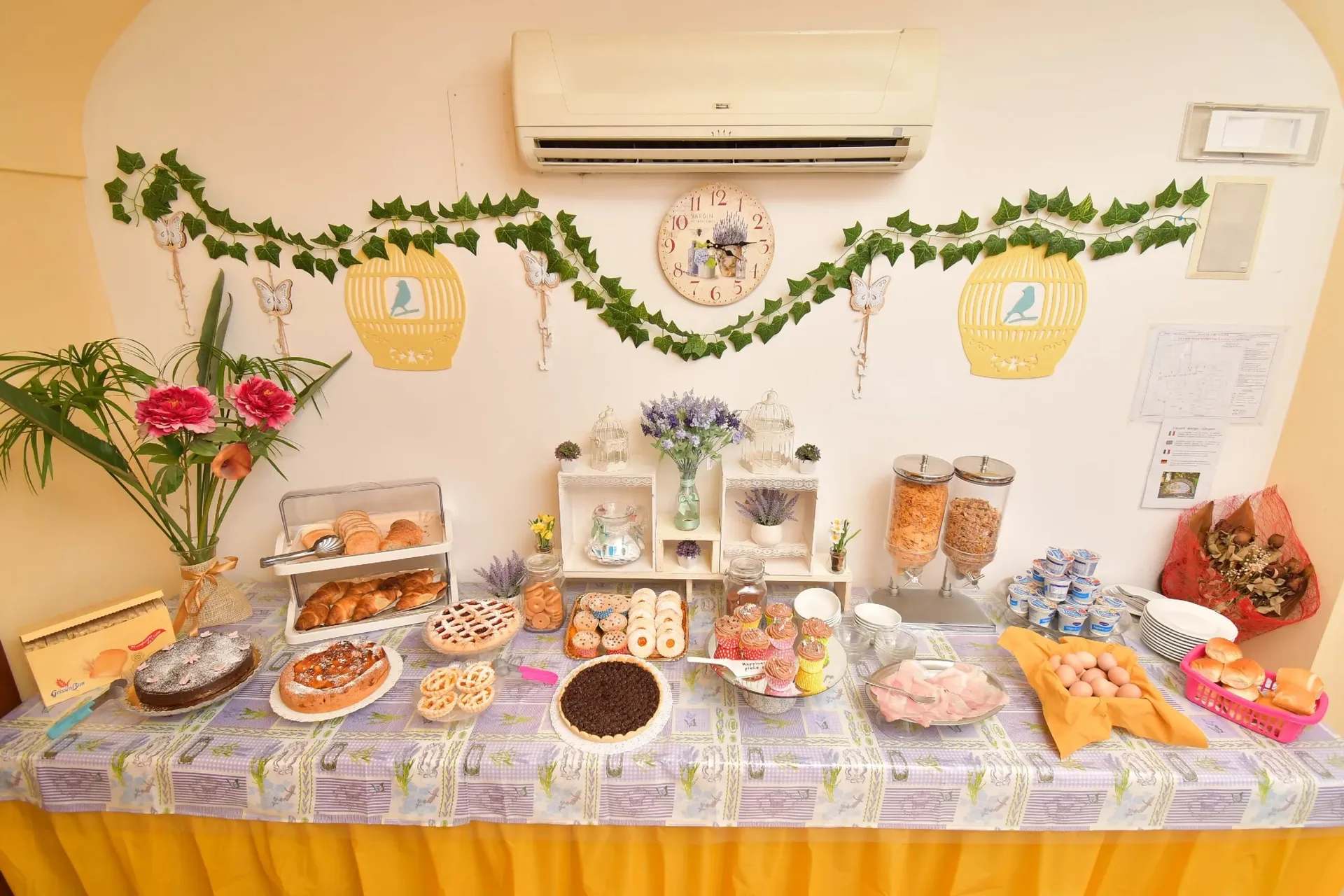 Buffet colazione con torte, cornetti, cereali e yogurt