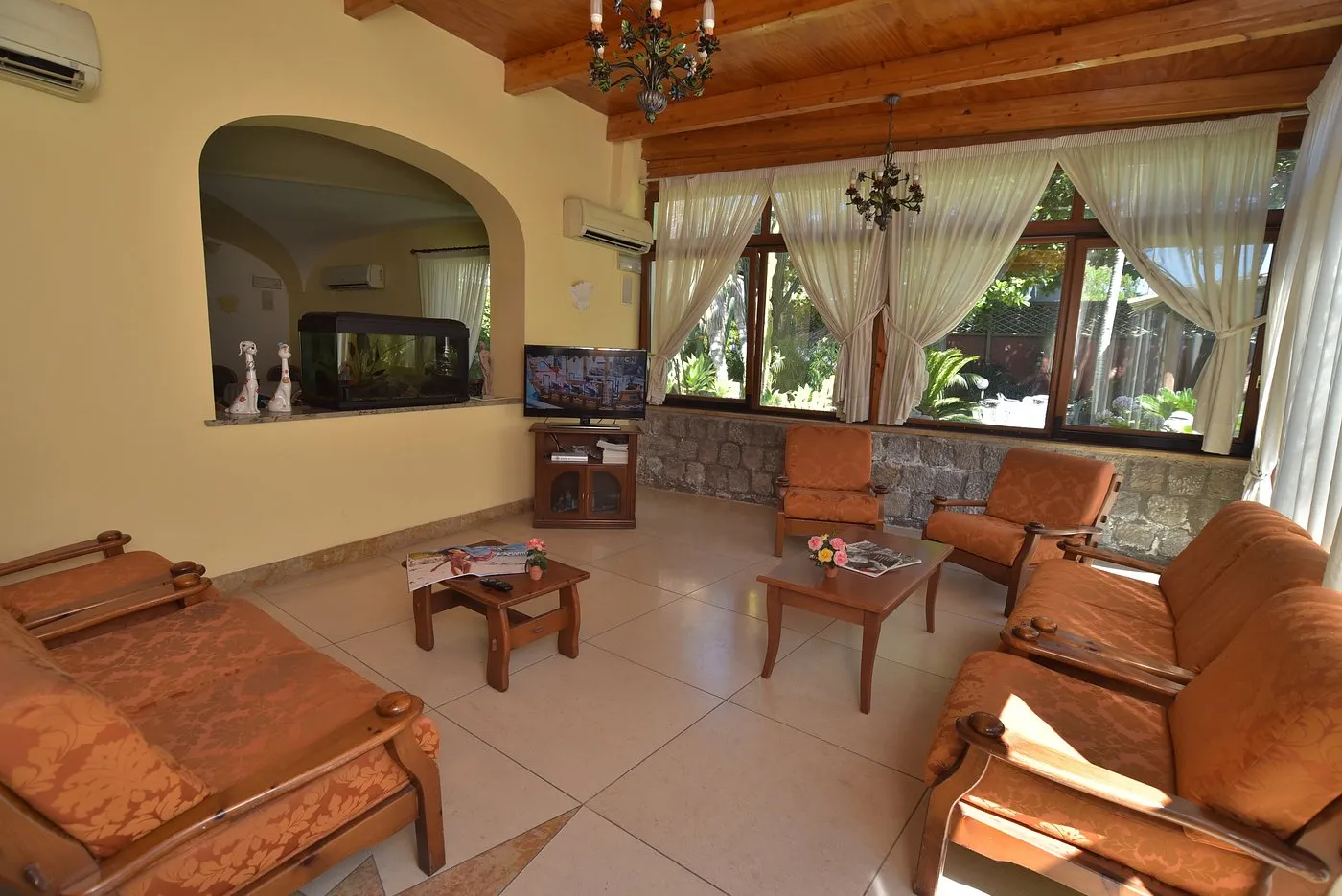 Sala soggiorno con poltrone arancioni, TV e acquario