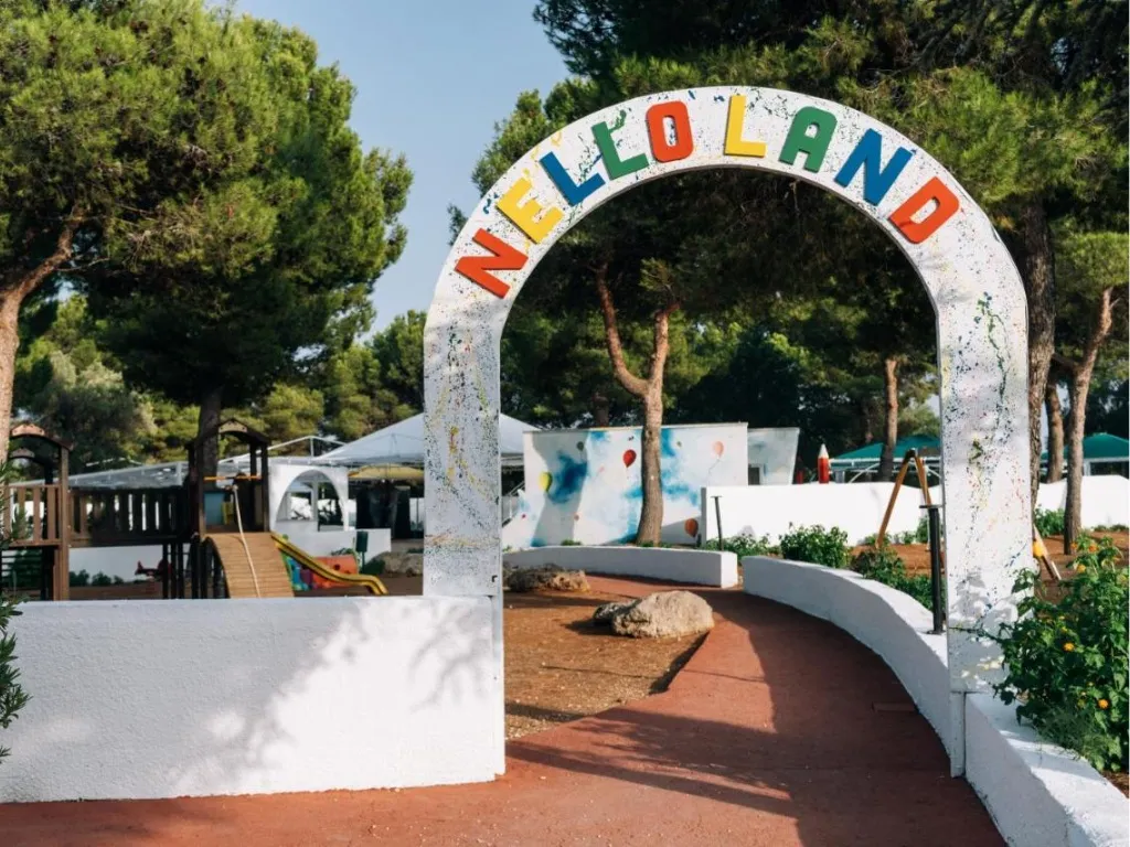 Arco d'ingresso colorato del Nello Land, area giochi per bambini tra i pini