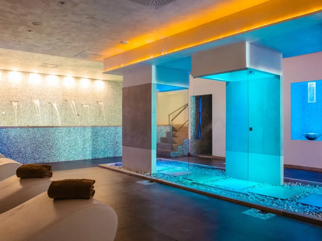 Zona benessere con getti d'acqua e illuminazione blu e arancione