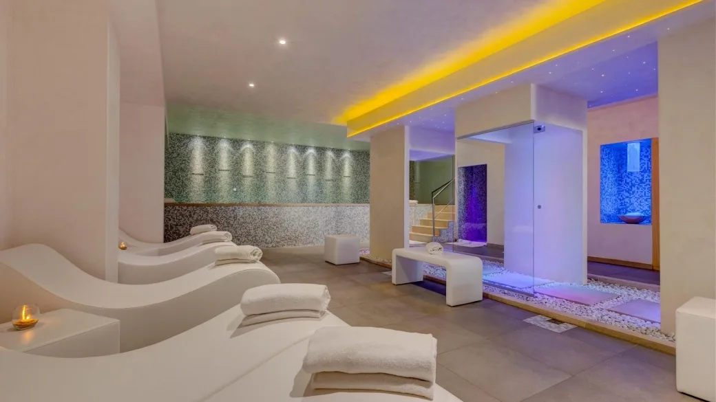 Area relax della spa con lettini ergonomici bianchi e docce emozionali