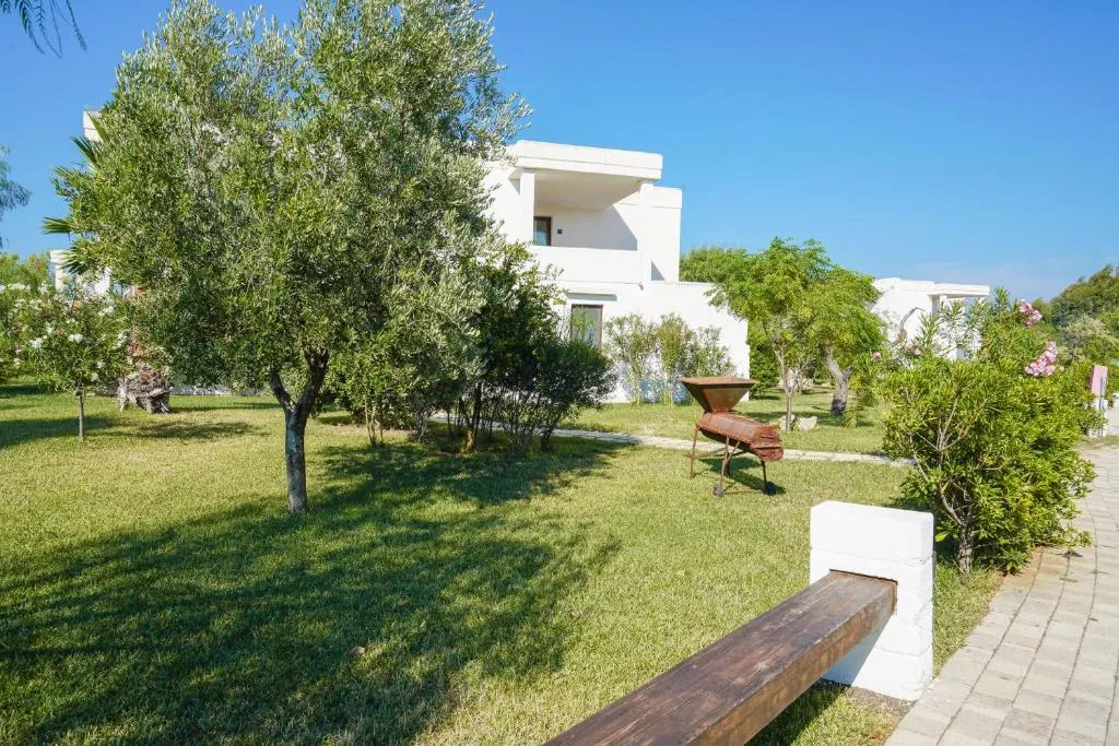 Giardino esterno con ulivi, prato verde e villa bianca