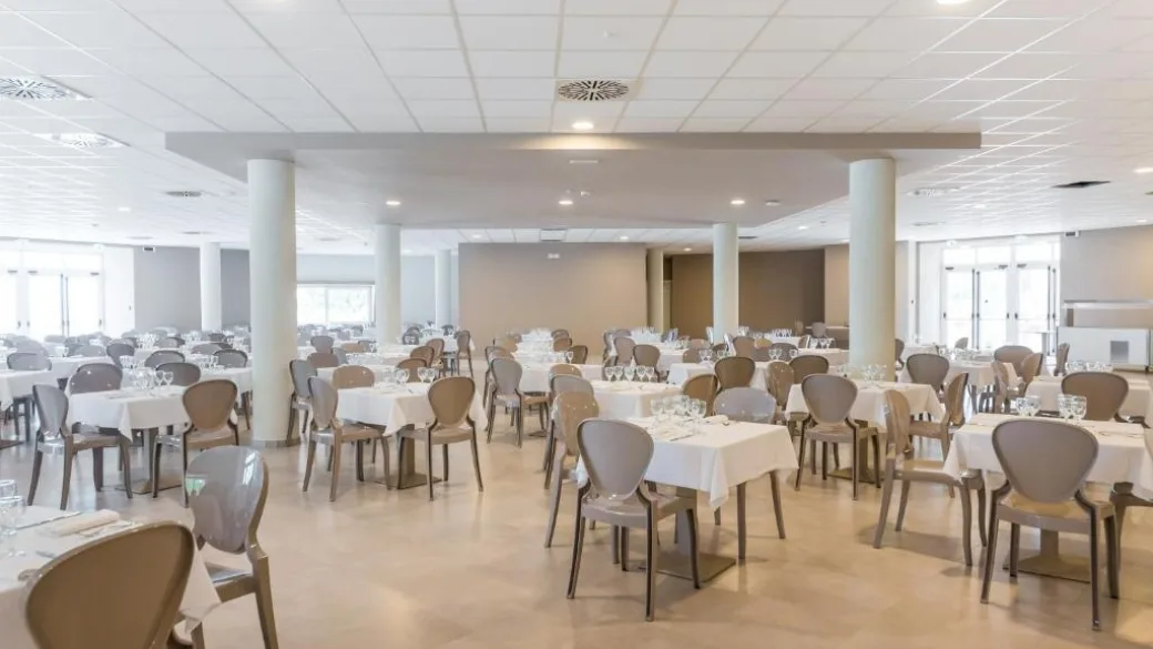 Sala ristorante interna con tavoli apparecchiati e sedie moderne