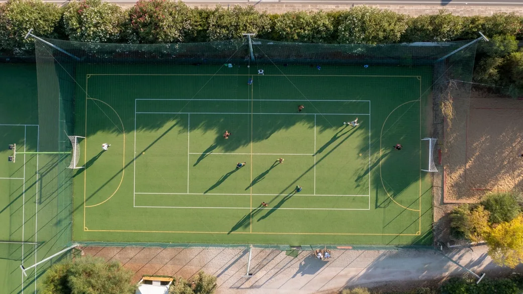 Vista aerea del campo sportivo polivalente in erba con giocatori