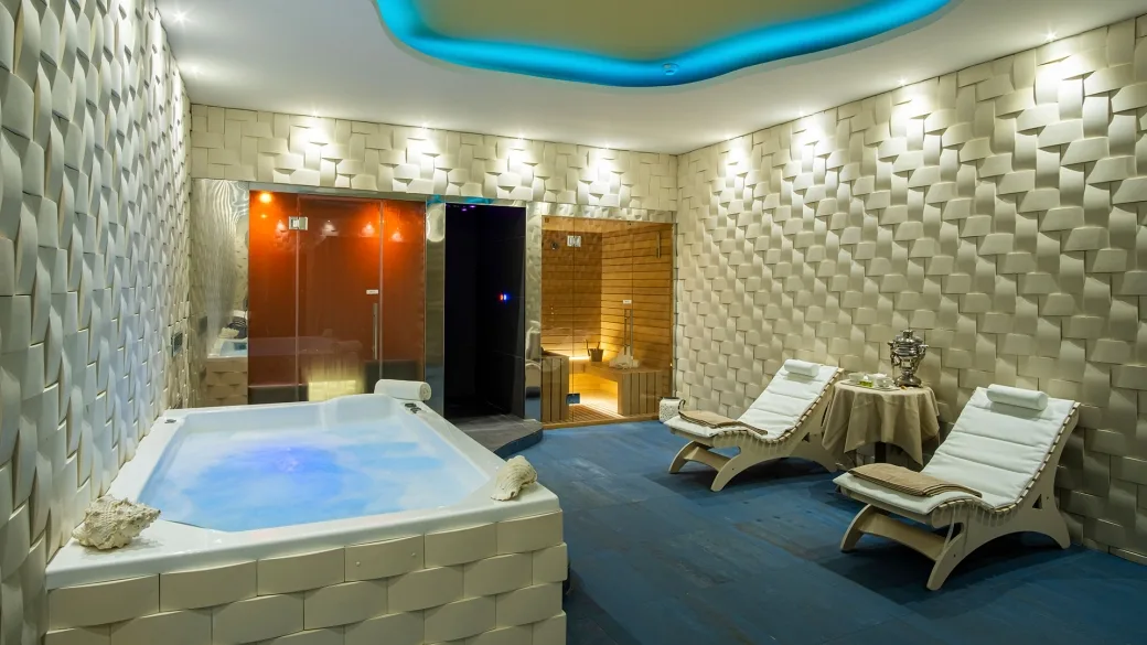 Zona spa con vasca idromassaggio, sauna e lettini relax