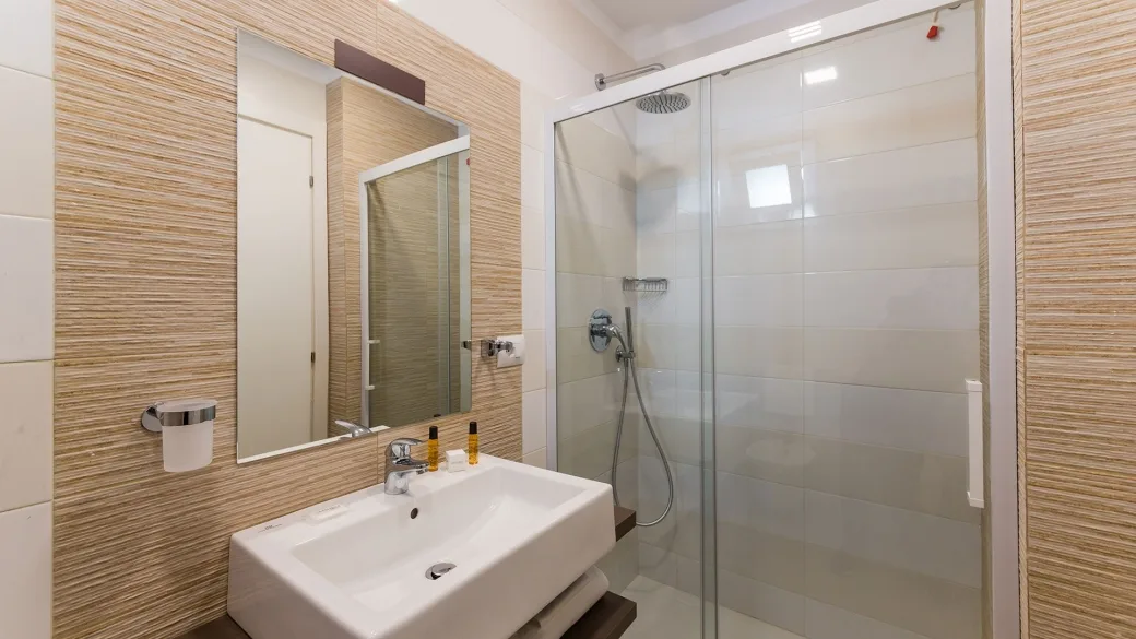 Bagno moderno della camera con doccia, lavabo e specchio