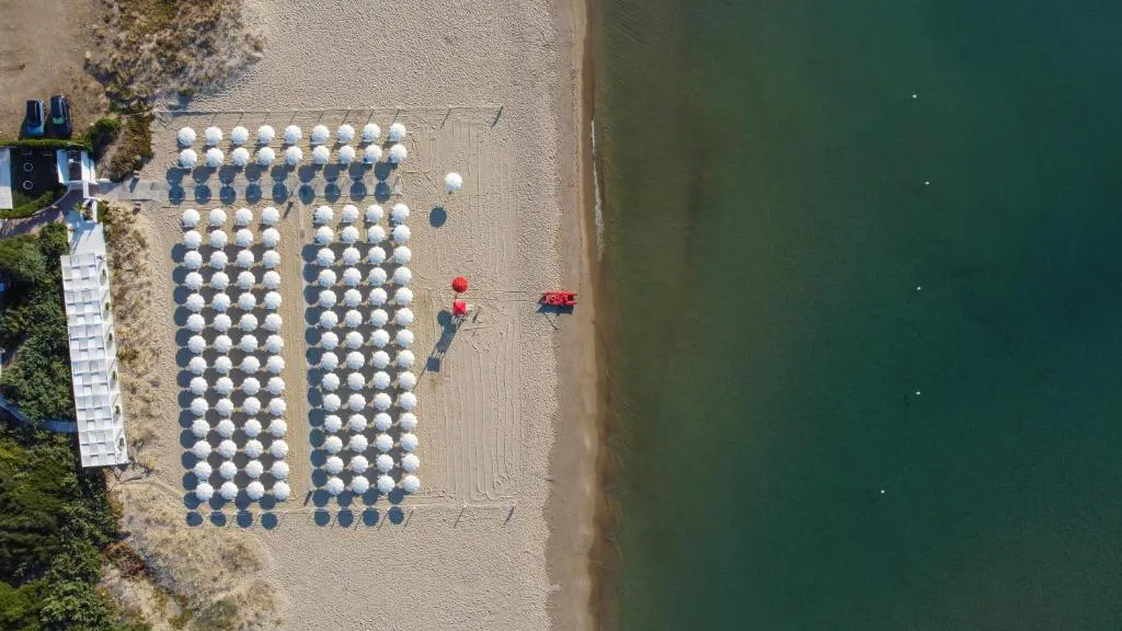 Vista aerea della spiaggia con ombrelloni ordinati lungo la costa