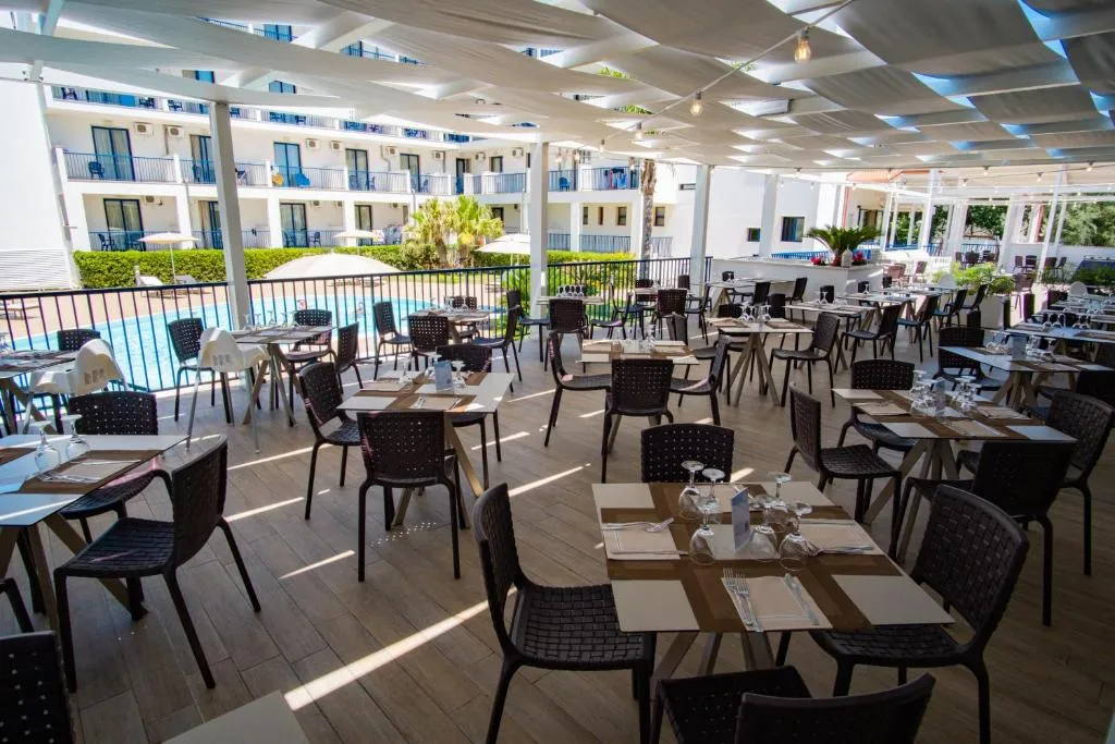Ristorante all'aperto con vista piscina e tavoli apparecchiati