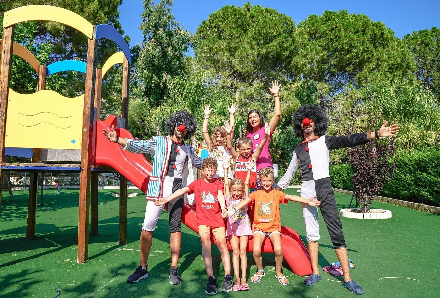Animatori vestiti da clown con bambini al parco giochi del resort