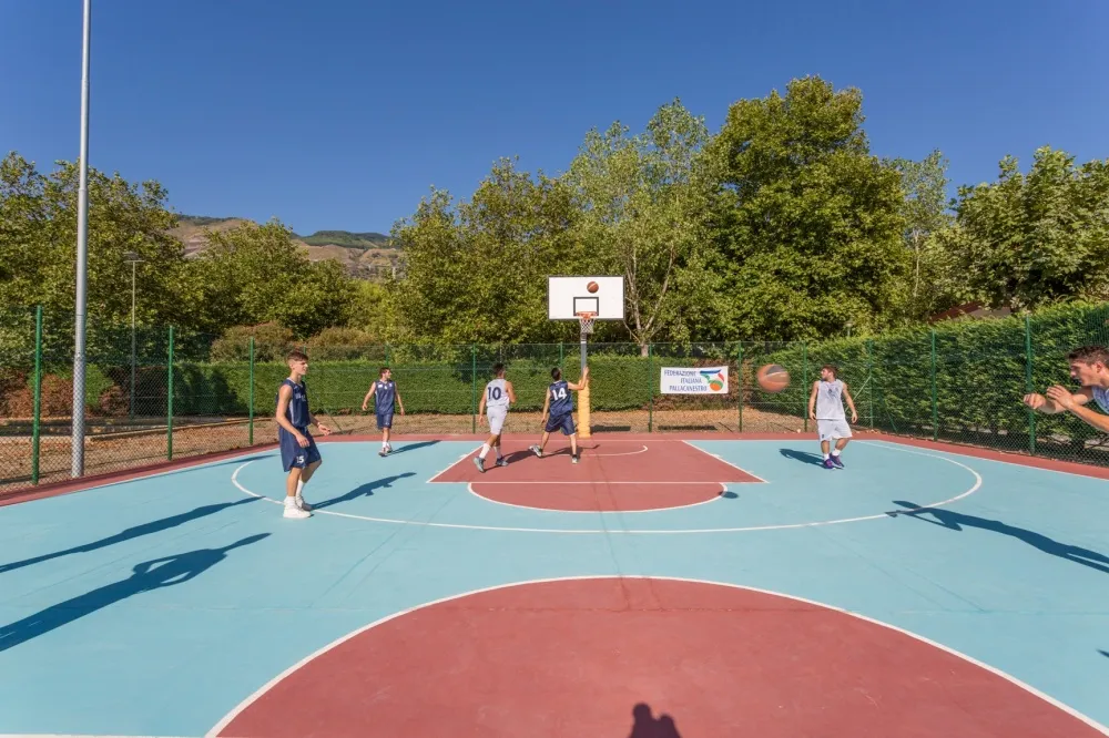 Ragazzi giocano a basket sul campo da pallacanestro del resort