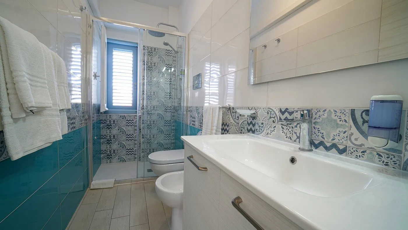 Bagno moderno con doccia, lavabo e piastrelle decorate in stile mediterraneo