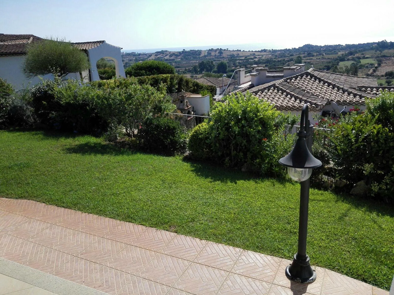 Giardino verde con lampione e vista panoramica sul mare e sulla campagna