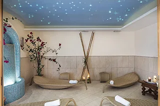 Zona benessere con lettini relax e soffitto a cielo stellato azzurro