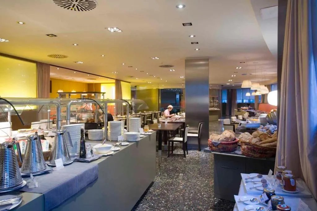 Sala colazione a buffet con piatti, pane e bevande