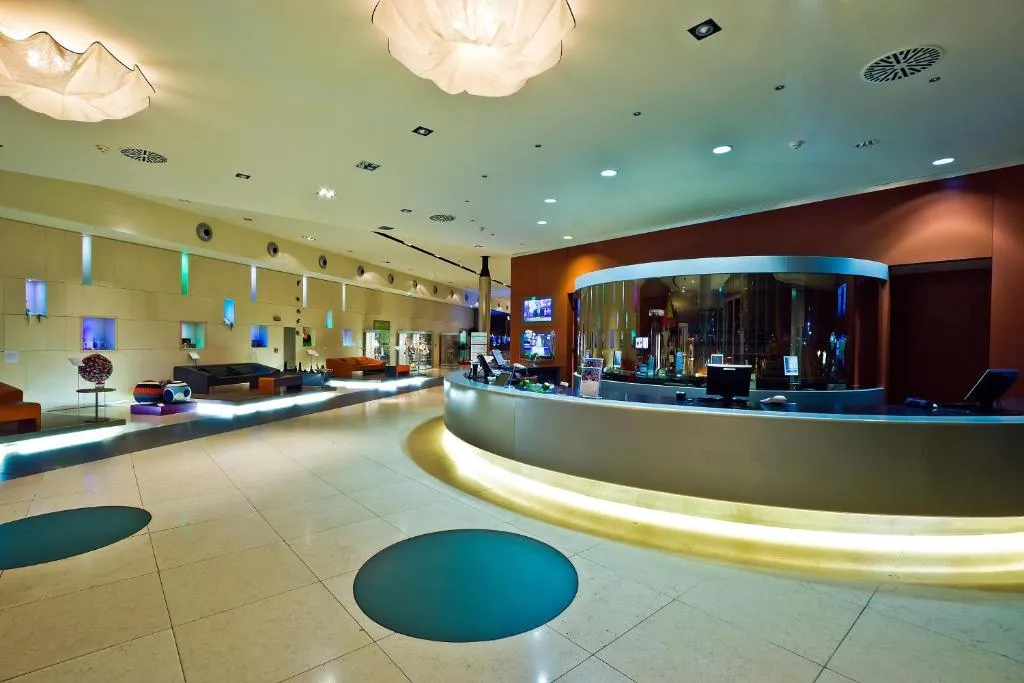 Reception moderna con bancone curvo illuminato e area lounge