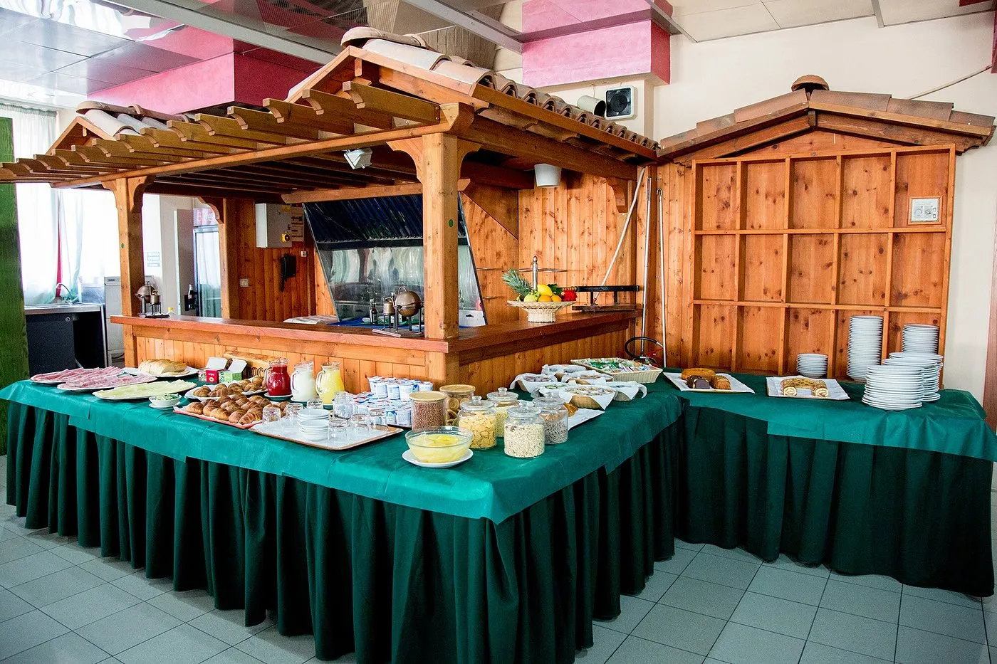 Dettaglio del buffet colazione con barattoli di cereali, yogurt e ananas a fette