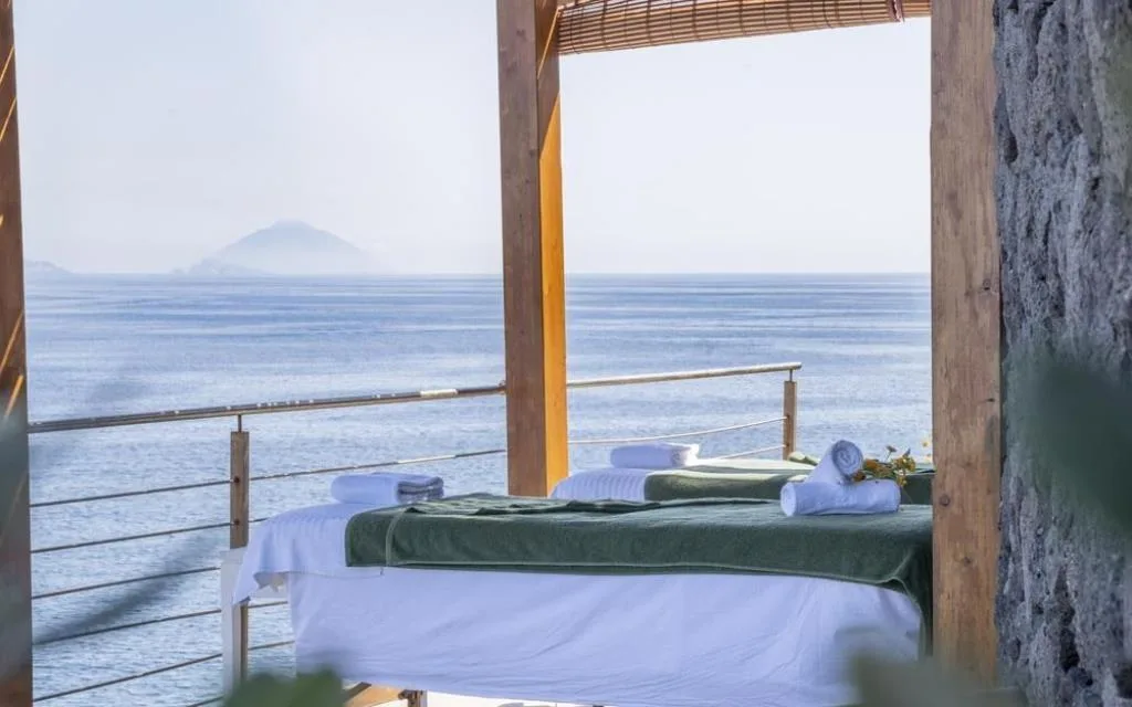 Lettini da massaggio all'aperto con vista sul mare e sul vulcano Stromboli