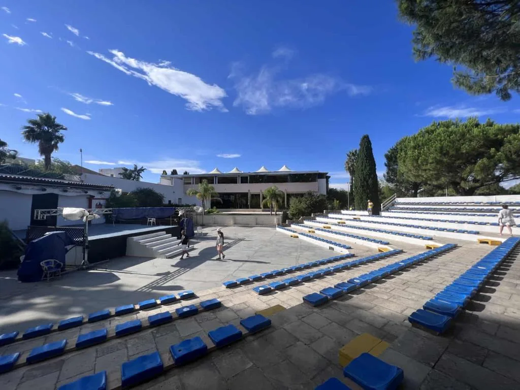 Anfiteatro all'aperto con gradinate e sedute blu per spettacoli serali