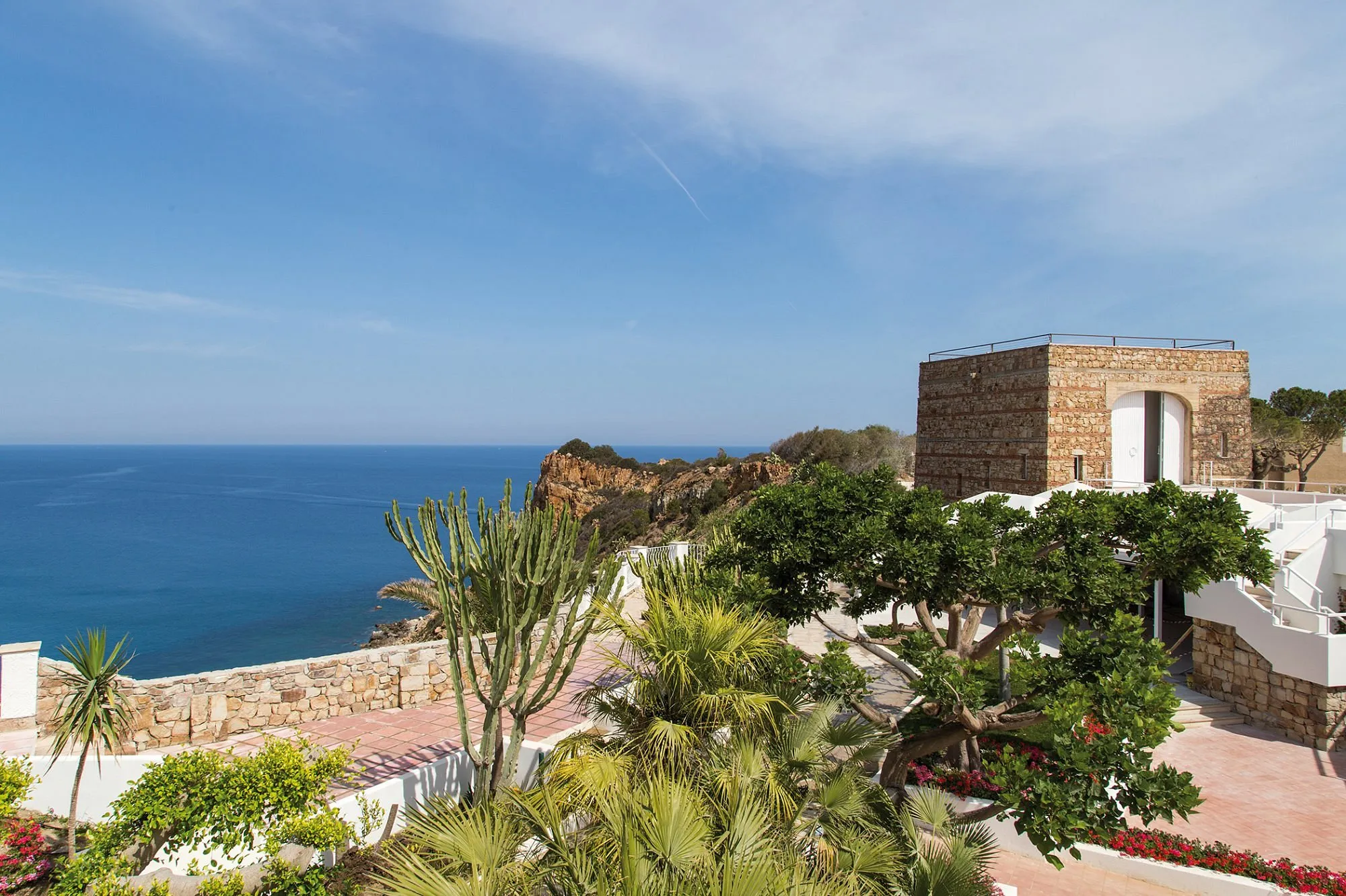 Terrazza panoramica con torre in pietra, giardino e vista mare