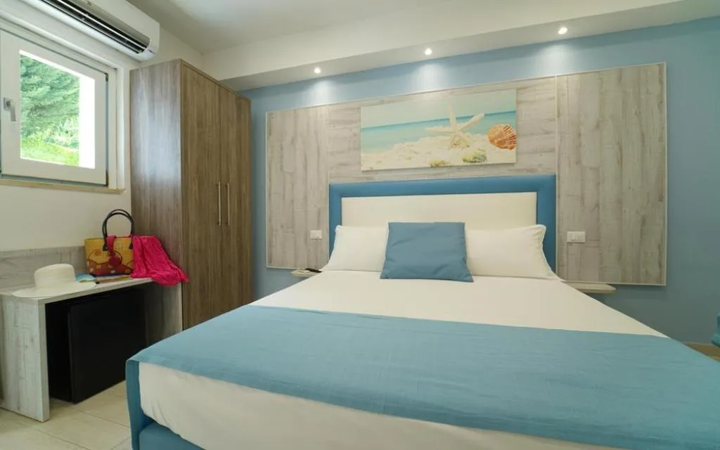 Camera matrimoniale in stile marino con letto blu e decorazione a tema spiaggia