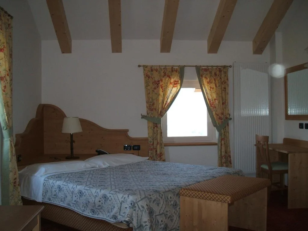 Camera matrimoniale con soffitto a travi e scrivania in legno