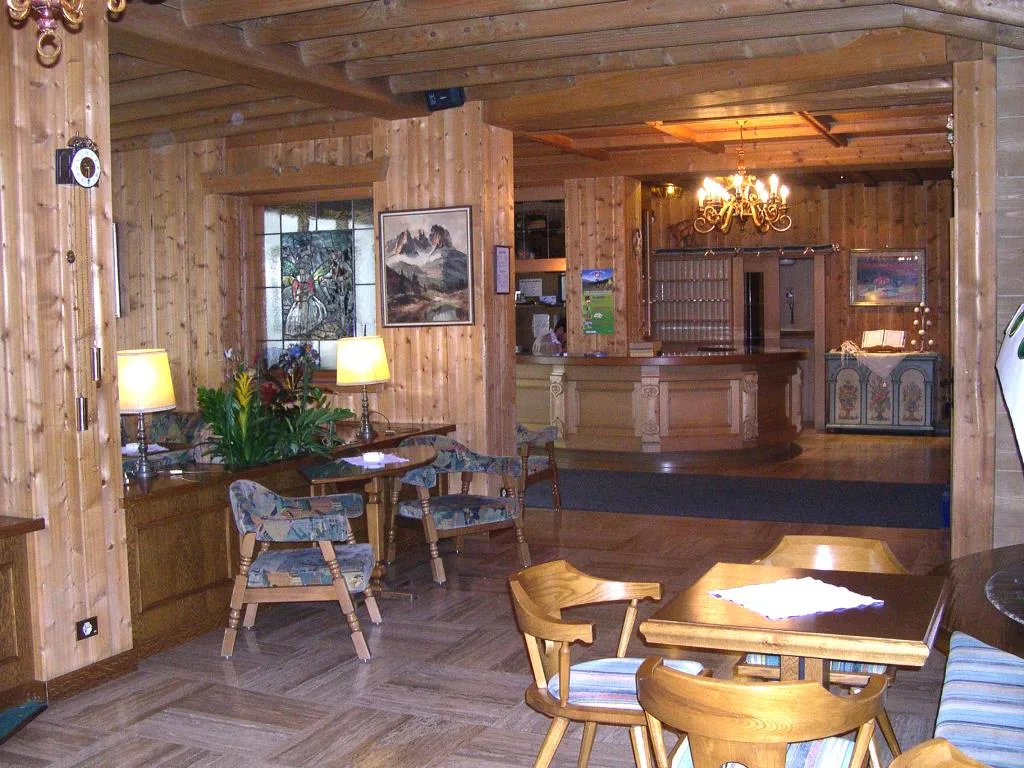 Hall dell'hotel con reception e arredi in legno in stile alpino