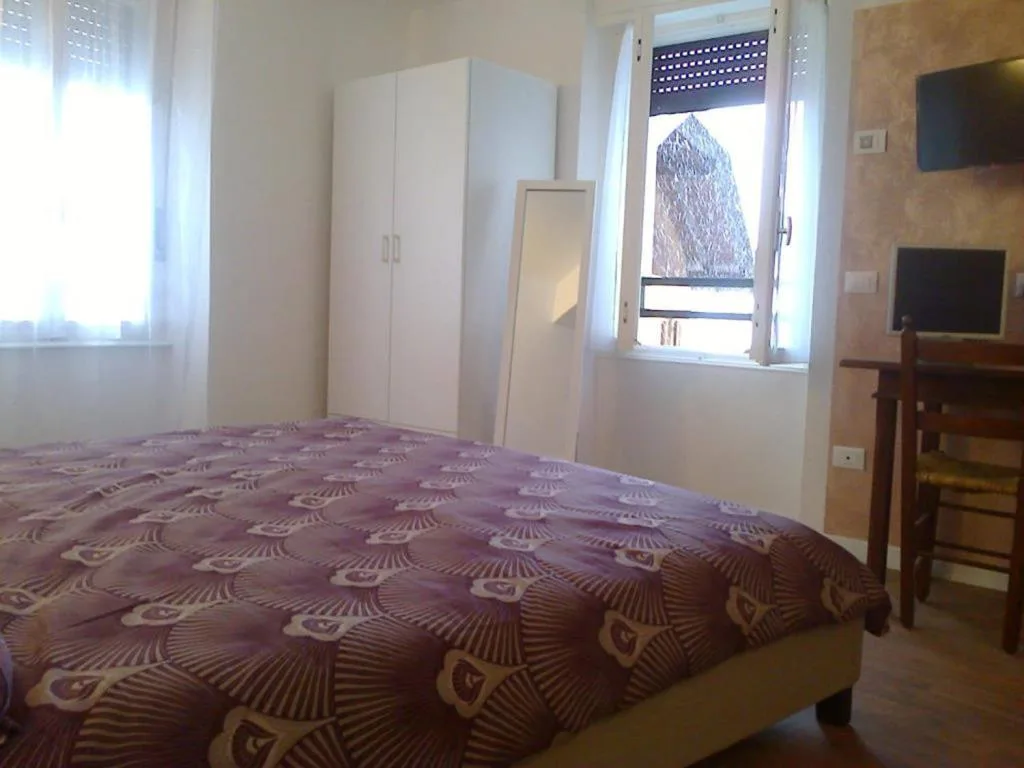 Camera con letto matrimoniale, armadio bianco, scrivania con TV e finestra