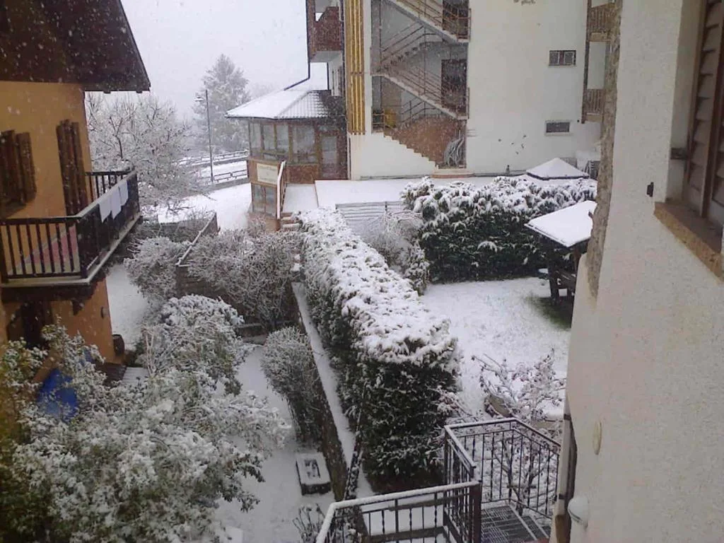 Vista del giardino e cortile dell'hotel innevati durante una nevicata